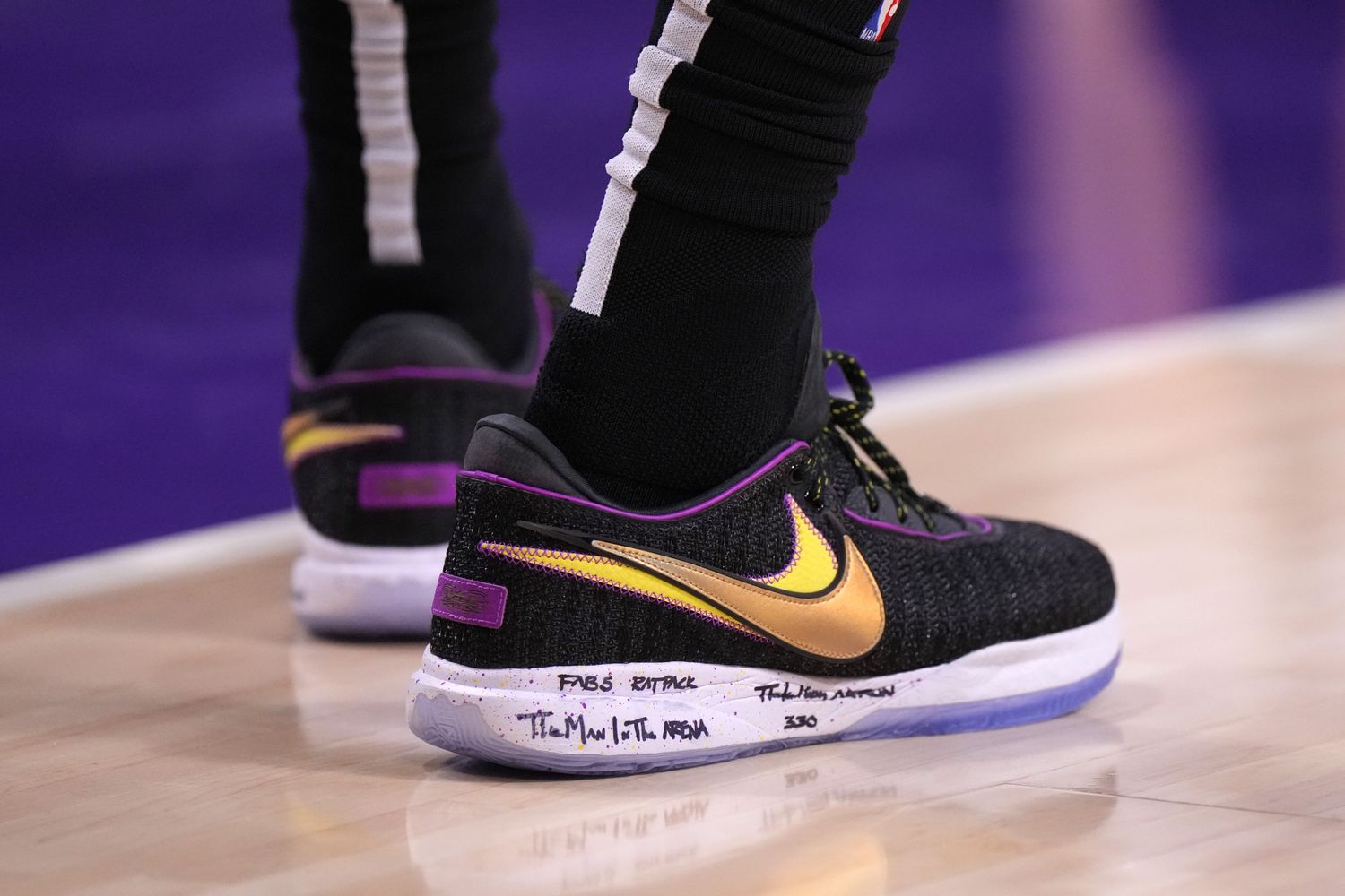 View of black and gold Nike LeBron shoes.